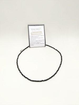 Gargantilla de pequeñas cuentas negras facetadas de turmalina sobre su tarjeta de presentación de Macerox.